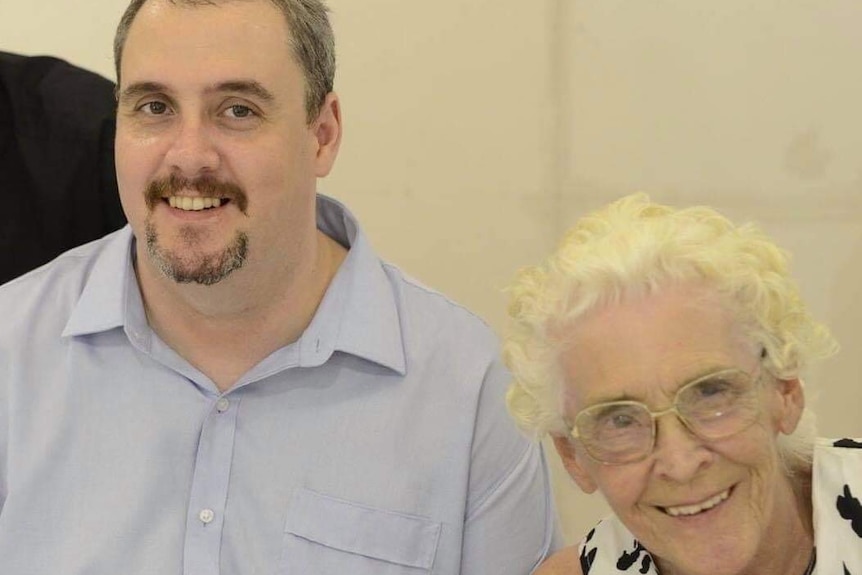 A man and his mother who is wearing glasses