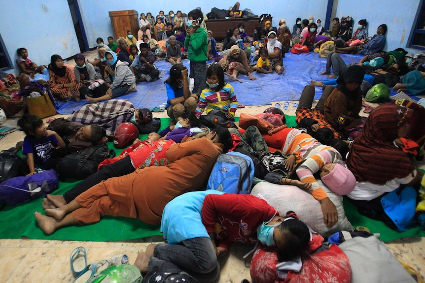 Villagers sleep at temporary shelter