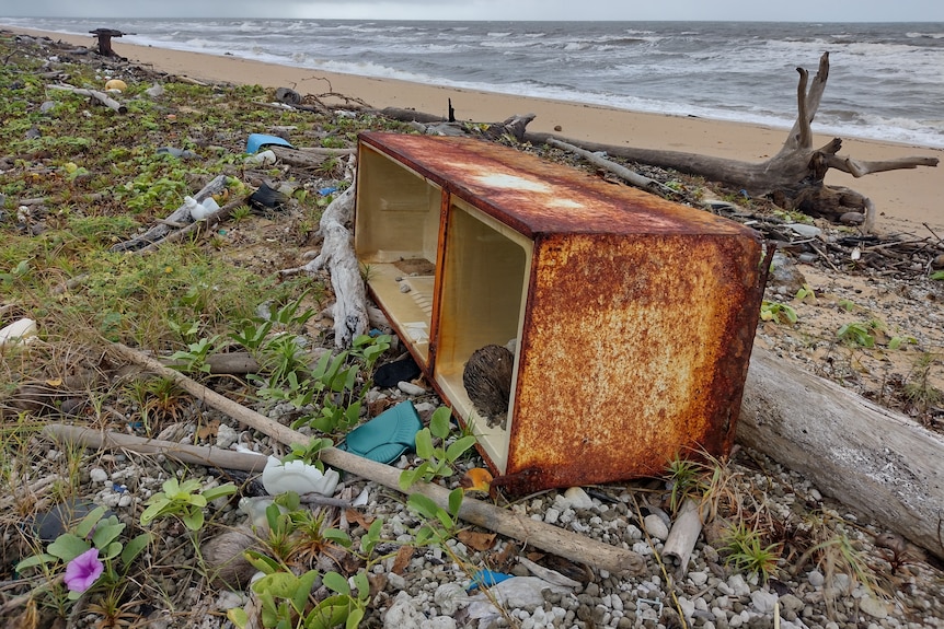 degraded plastic and rusted metal marine waste is visible on the Cape York beach coastline