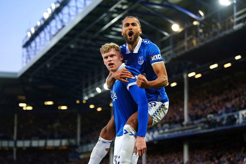 Dominic Calvert-Lewin pumps his fist as he celebrates an Everton goal while being piggy-backed by Jarrad Branthwaite.