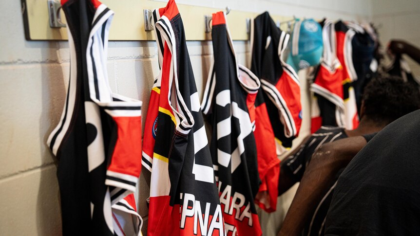 a photo showing a Epenarra Saints Jersey hanging on wall hooks