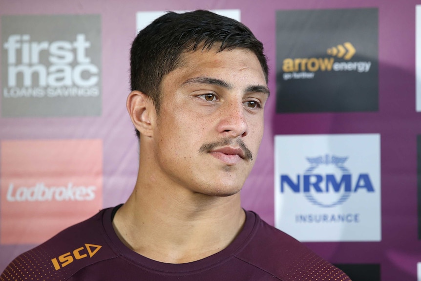 A Brisbane Broncos NRL player looks ahead as he listens to a question at a media conference.