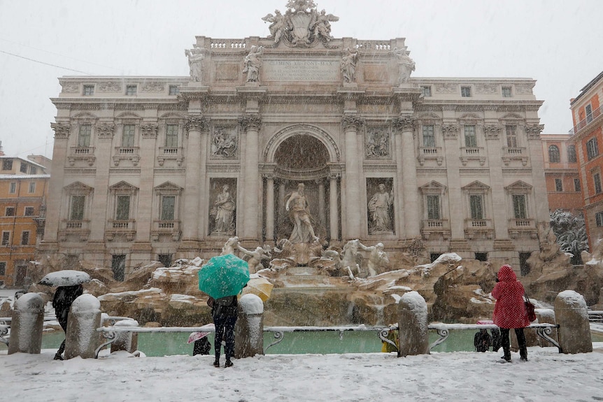 Trevi fountain is covered in snow during a heavy snowfall in Rome.