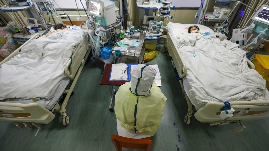 A medical worker monitors patients in the isolated intensive care unit