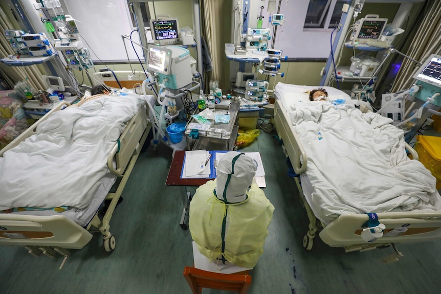 A medical worker monitors patients in the isolated intensive care unit