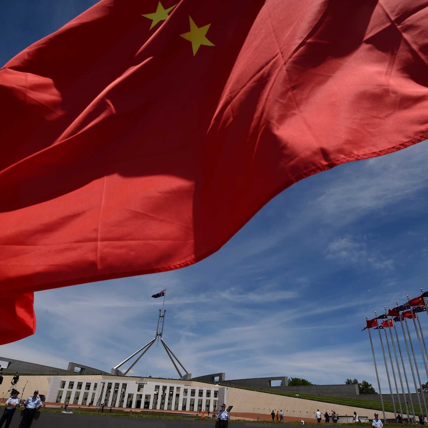 Chinese flags fly high outside the Australian Parliament House in Canberra