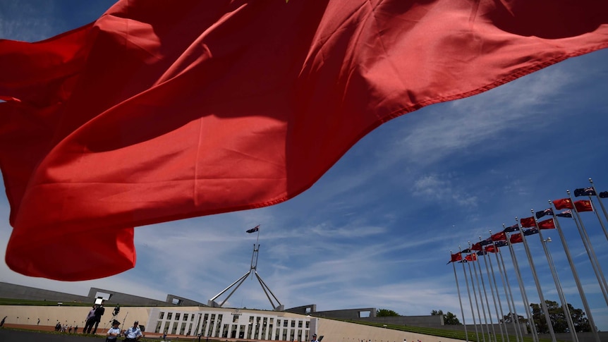 Chinese flags fly high outside the Australian Parliament House in Canberra