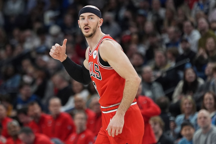 Chicago Bulls NBA player Alex Caruso gives a thumbs up during a game.