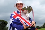 Hannah Green, with the Australian flag draped over her shoulders, holds the LPGA Tour Women's World Championship trophy.