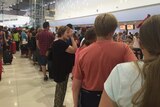 A long line of people waiting at Perth Airport.