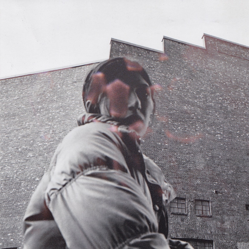 a woman in a coat in front of a large building