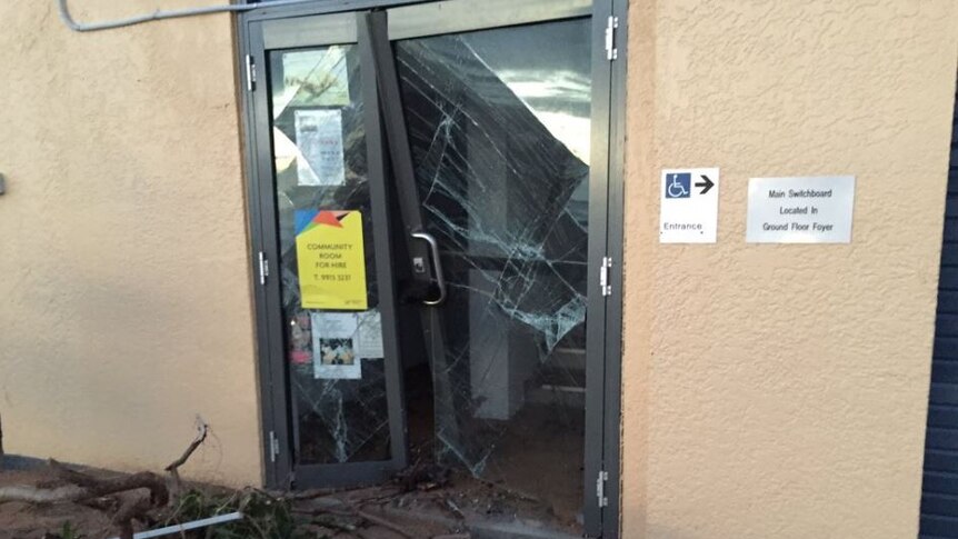 A smashed door at the Collaroy Swimming Club, with branches out front.
