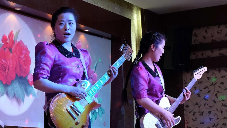 North Korean women playing electric guitars and singing