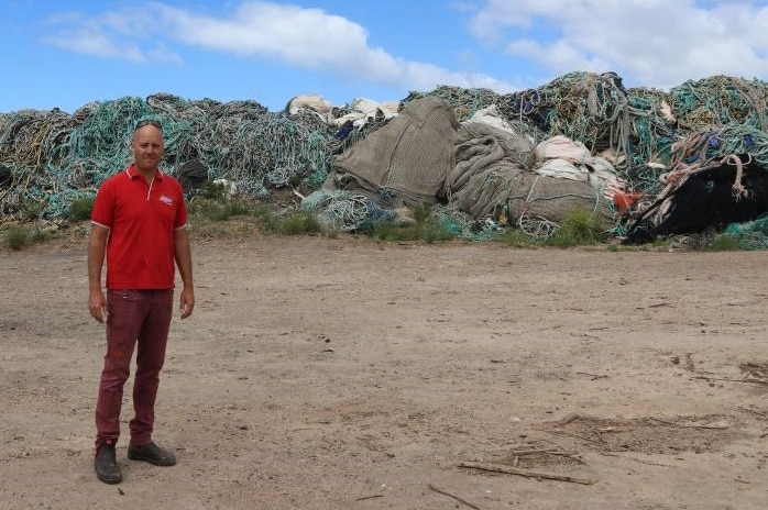 Man standing in front of pile of netting