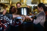 Women holding pot in kitchen