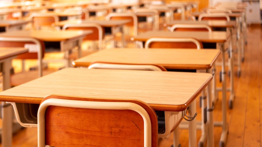 Rows of school desks with chairs and a blackboard