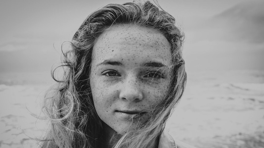 A photo of 12 year old Ali smiling at the camera in black and white