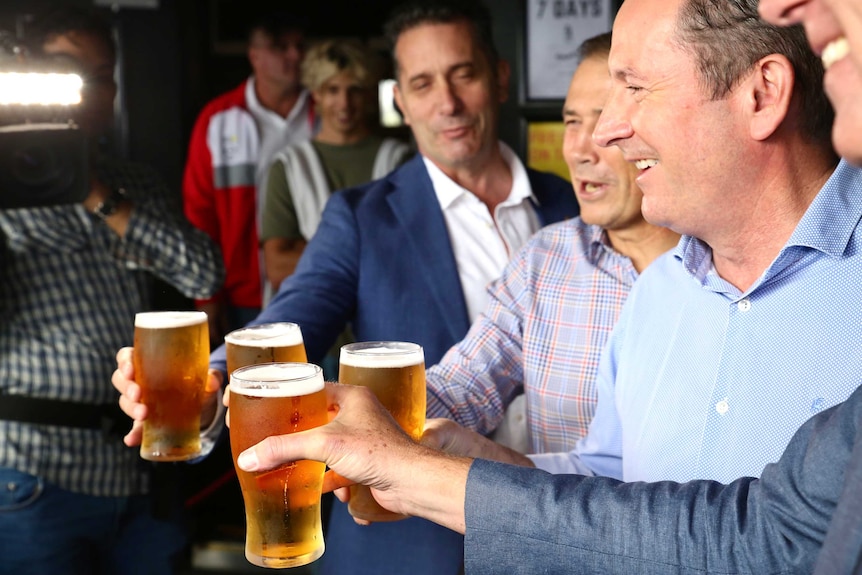 Tourism Minister Paul Papalia, Health Minister Roger Cook and Premier Mark McGowan clink beer pints.