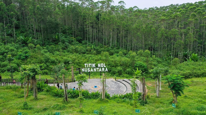 A sign read 'Titik Nol Nusantara' with greenm jungle behind it. 