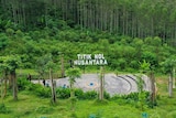 A sign read 'Titik Nol Nusantara' with greenm jungle behind it. 