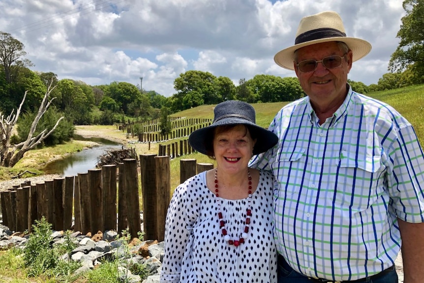 Ruth and Stephen Carter standing in front of the repaired stretch of river.