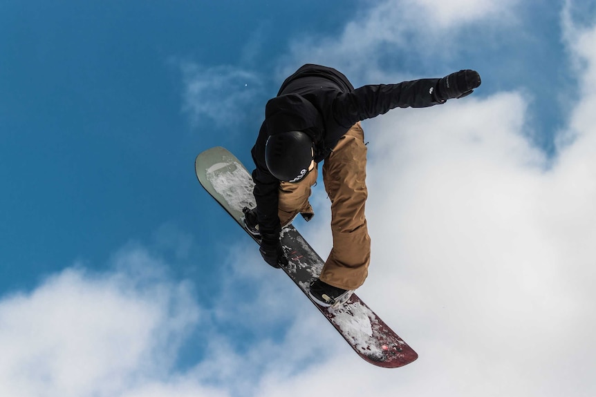 Snowboarder gets some air in the alps.