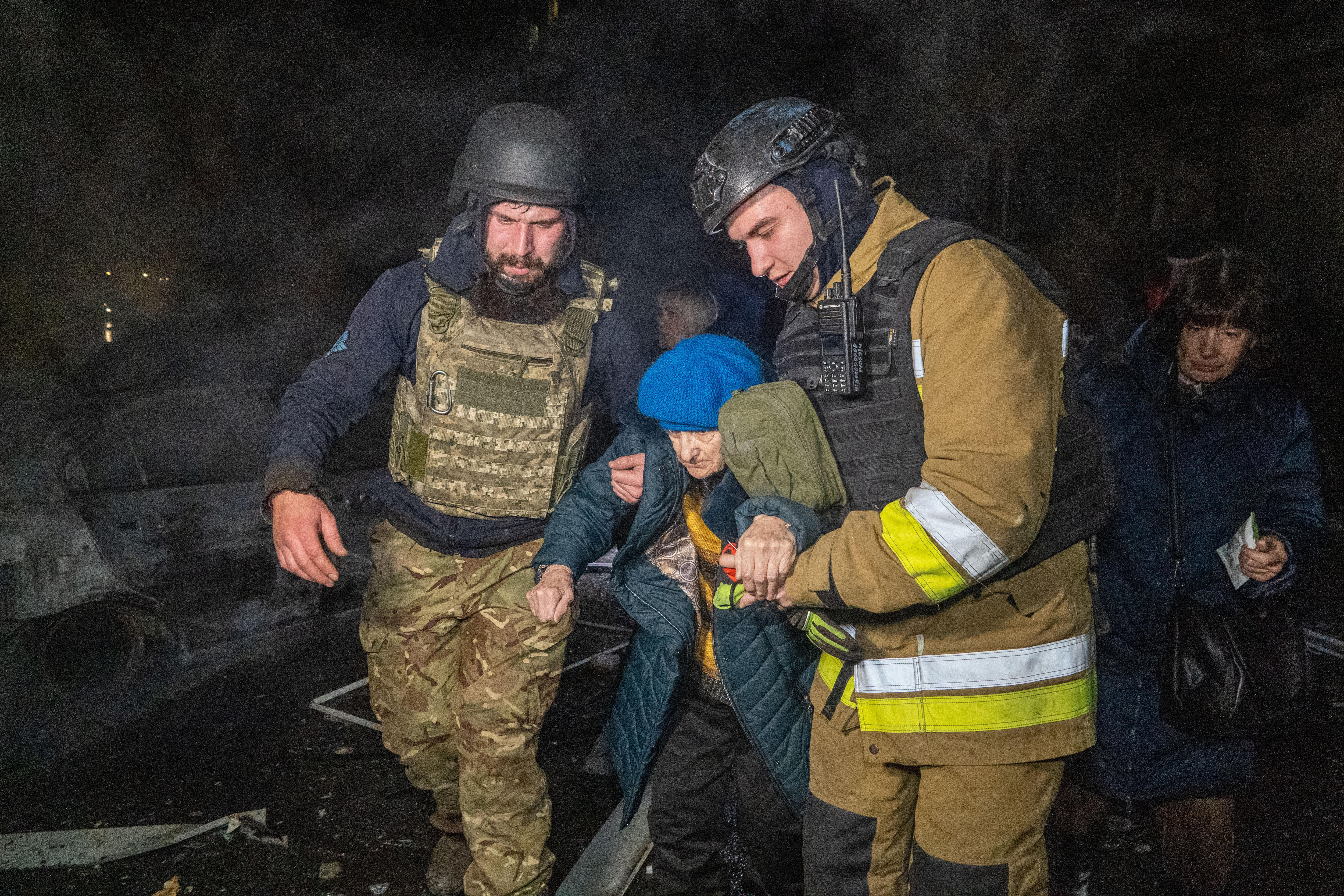 Rescuers evacuate an elderly woman after a residential building was hit in Ukraine 