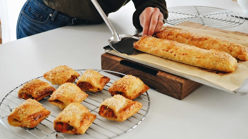 Bite-sized chicken sausage rolls cool on a wire tray, a fun family dinner.