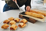 Bite-sized chicken sausage rolls cool on a wire tray, a fun family dinner.