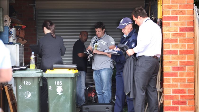 Police investigate the garage of a town house