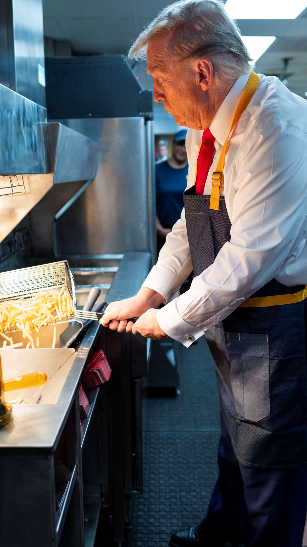 Donald Trump in profile dispensing fries in a McDonald's kitchen