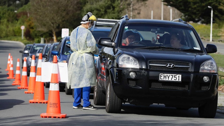 Medical staff prepare take a COVID-19 test from a visitor to a drive through testing point in Christchurch, New Zealand.