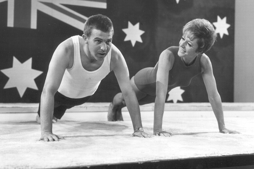 black and white photo of a man and a woman in a plank position doing exercise