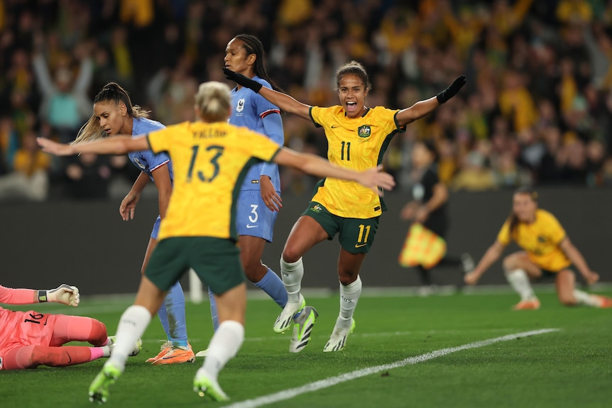 Australia's Mary Fowler throws her arms out and smiles after a goal against France.