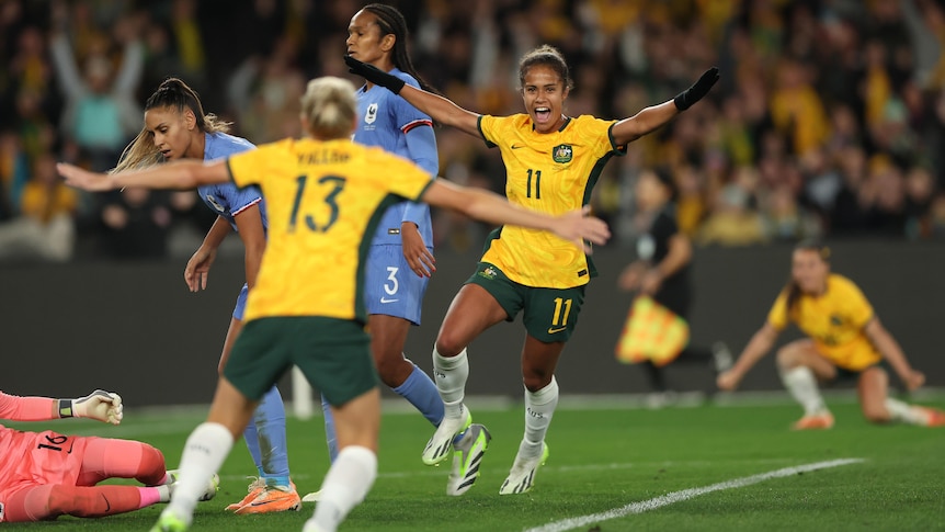 Australia's Mary Fowler throws her arms out and smiles after a goal against France.