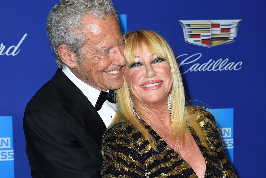 A woman and a man hugigng at a red carpet event 