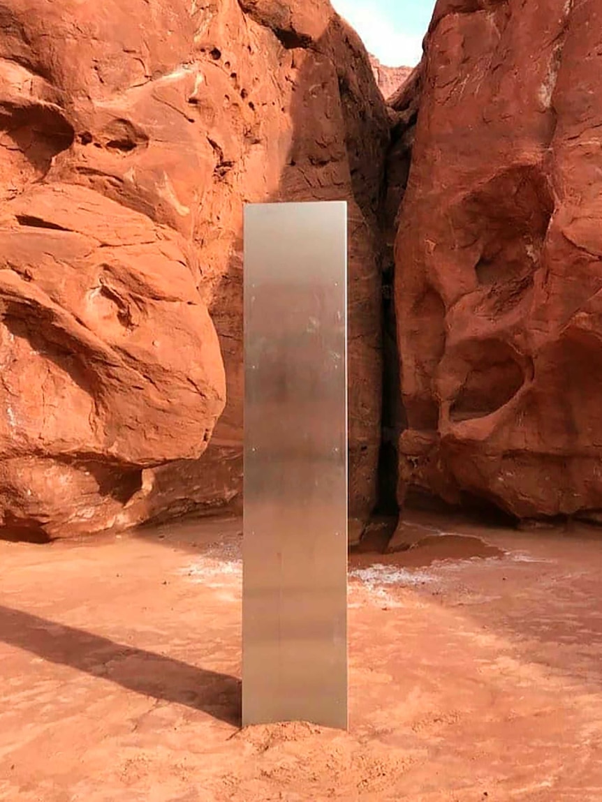 A shiny metal structure stands in a red rock canyon