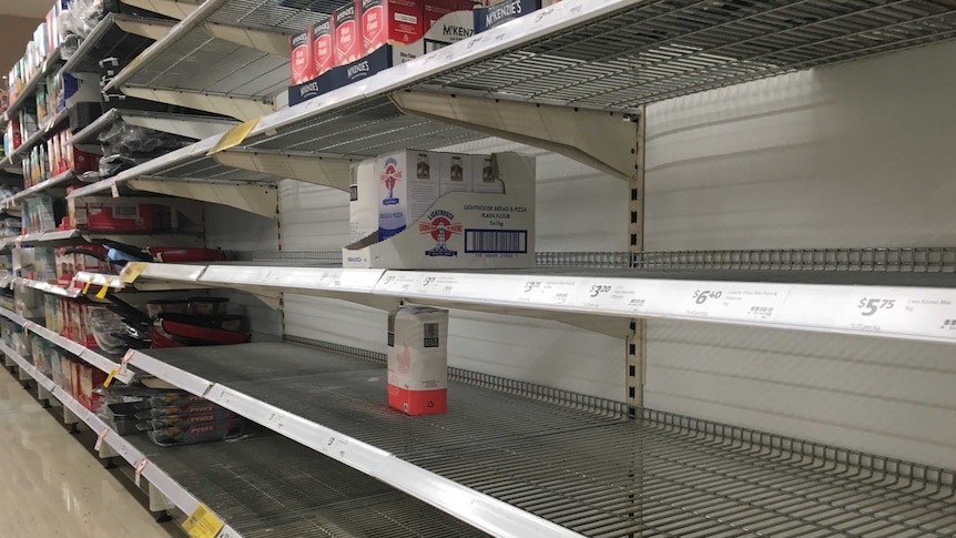 rows of supermarket shelves have been emptied of flour
