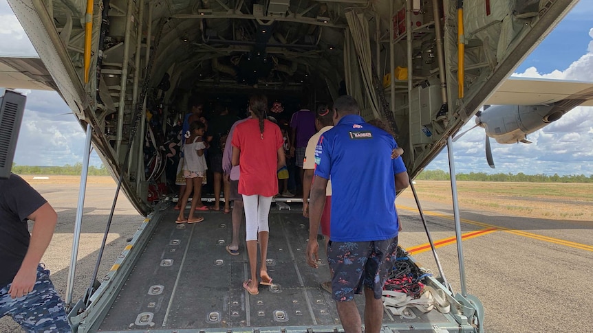 Residents boarding a massive defence force plane.