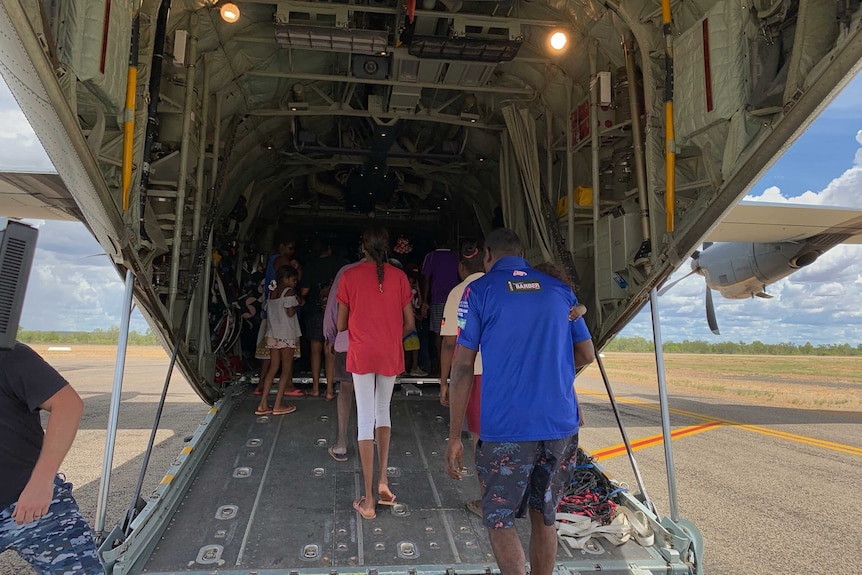 Residents boarding a massive defence force plane.