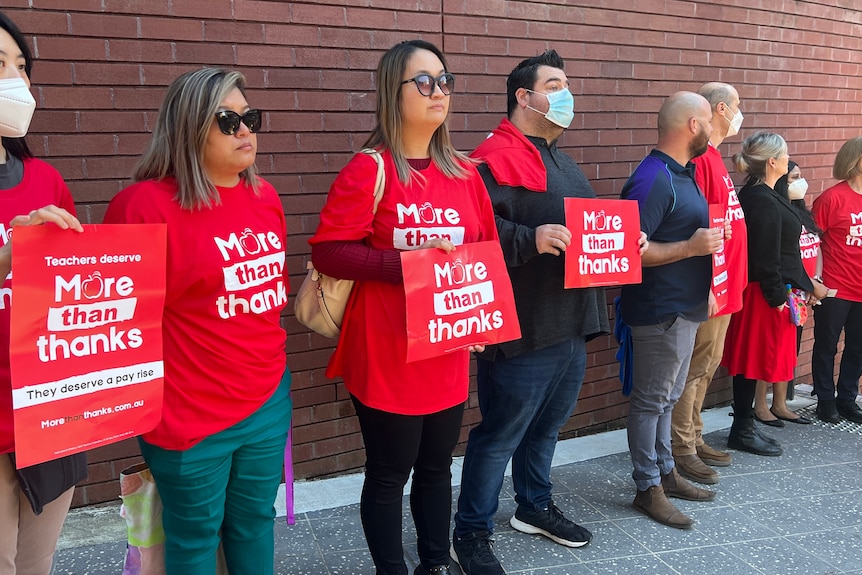 Teachers protesting holding signs