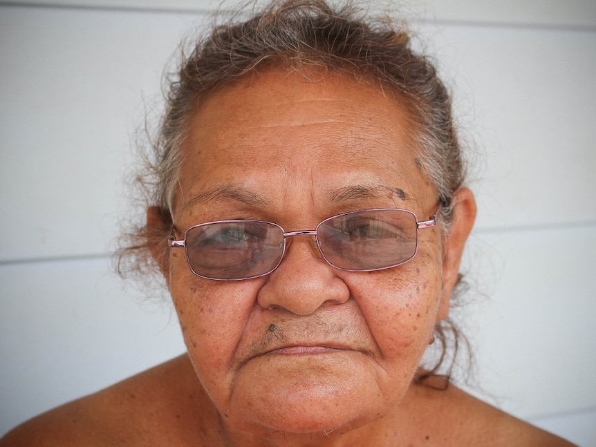 A portrait of Indigenous woman Beryl Charger looking with a serious expression at the camera