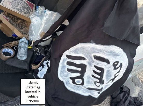 Bandeira caseira do Estado Islâmico na traseira de um carro dirigido por homens armados de Bondi Beach, com pizza e uma garrafa de água também visíveis.
