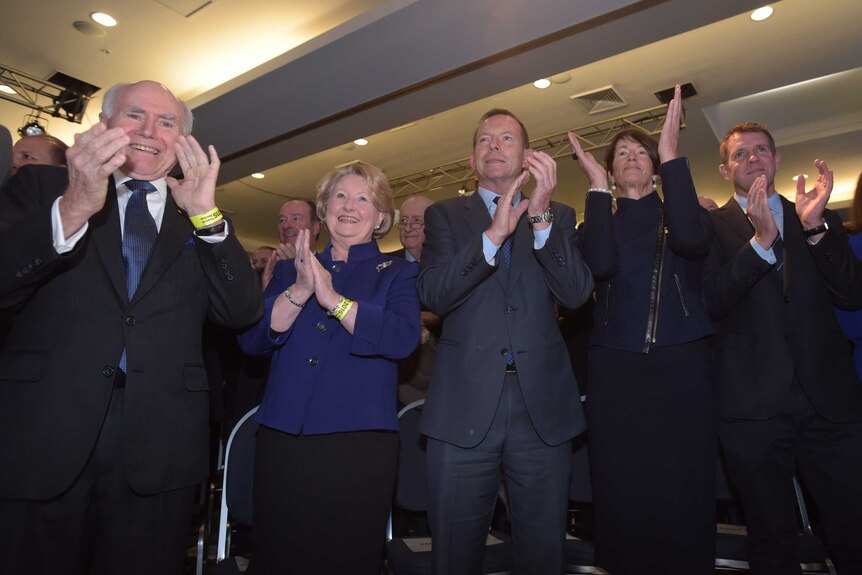 John Howard, his wife Janette, former Australian Prime Minister Tony Abbott, his wife Margie and NSW Premier Mike Baird clap.