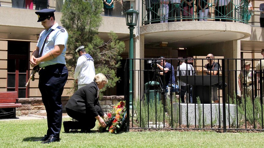 Wreaths are laid at the temporary eternal flame during Brisbane's Remembrance Day service in Anzac Square.