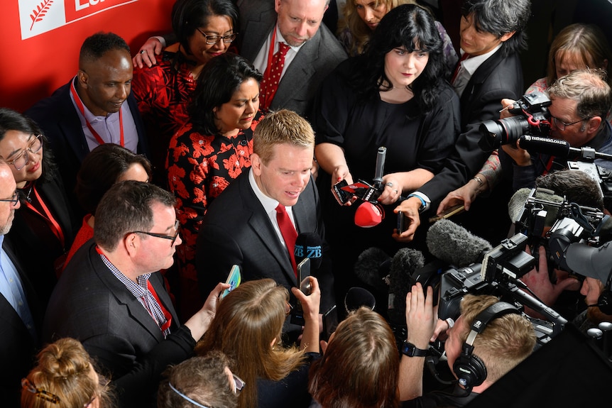 Chris Hipkins is surrounded by media. 