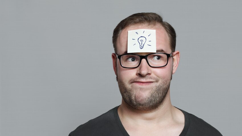 A man with a yellow post-it note stuck to his forhead.