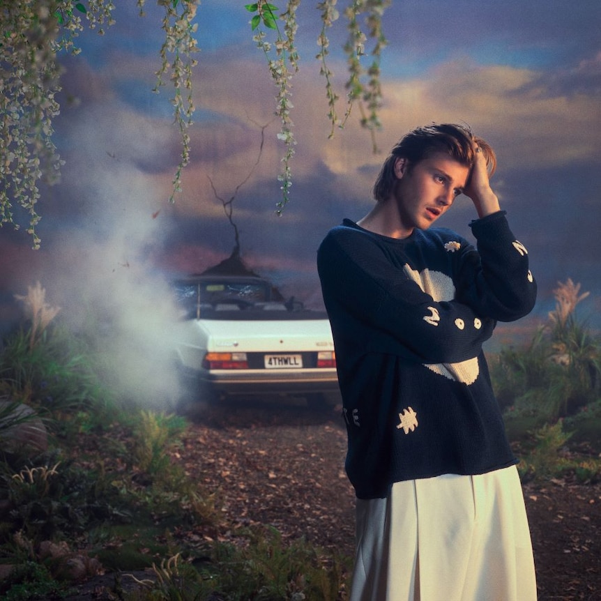 Photograph of Ruel with car and smoke in the background.