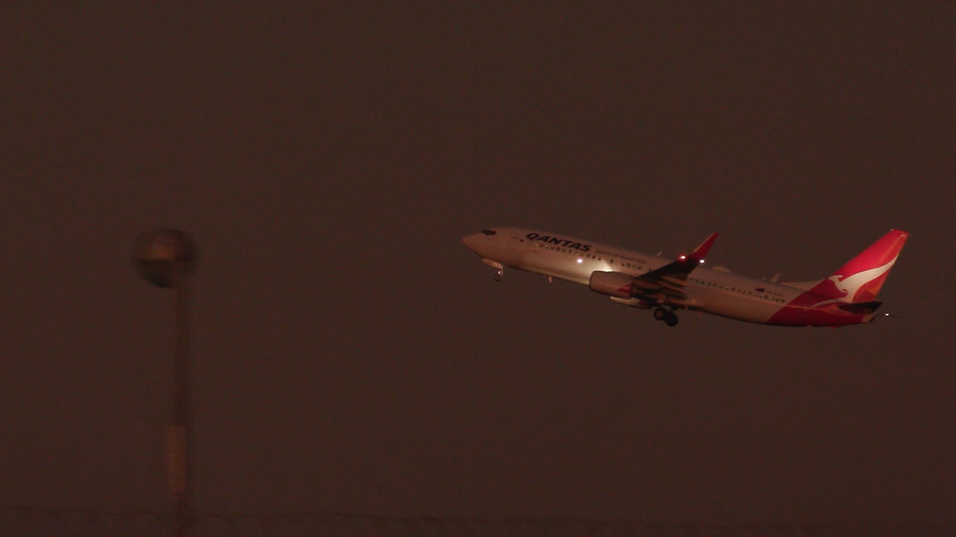 A Qantas plane flies at night
