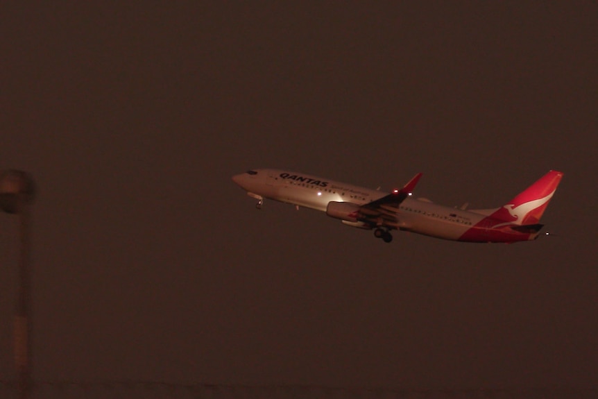 A Qantas plane flies at night